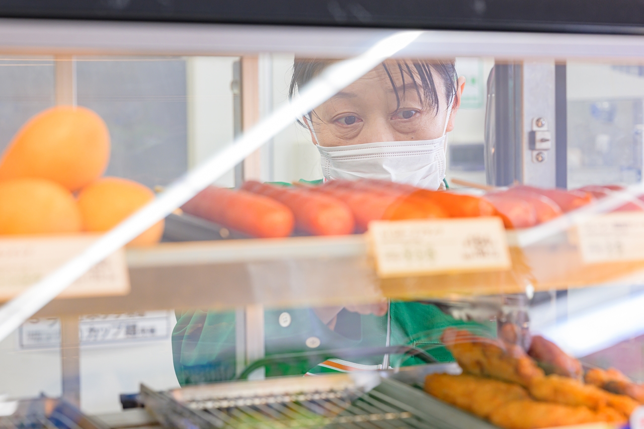 商品を並べるスタッフ